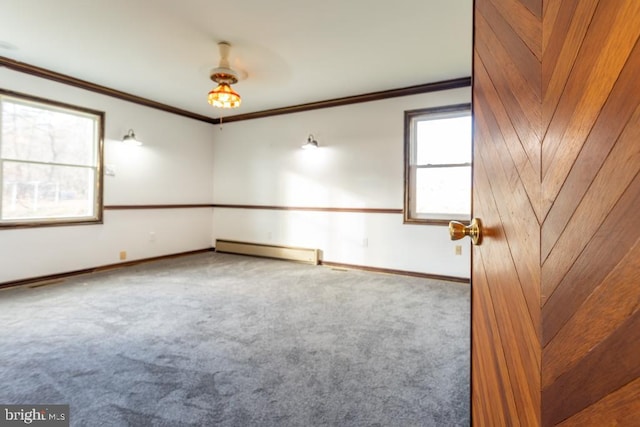 empty room featuring carpet, baseboard heating, and crown molding