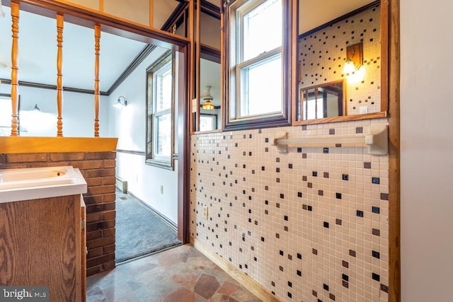 bathroom with vanity, tile walls, and crown molding