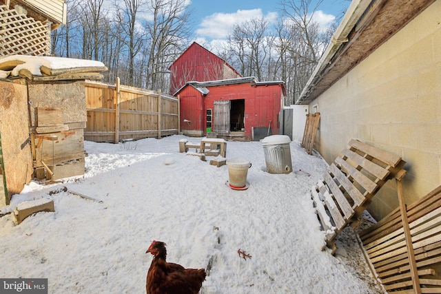 snowy yard featuring an outdoor structure