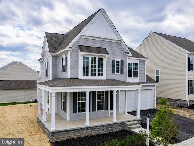 back of property with a porch and a garage