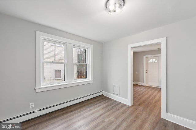 spare room with light hardwood / wood-style flooring and a baseboard heating unit