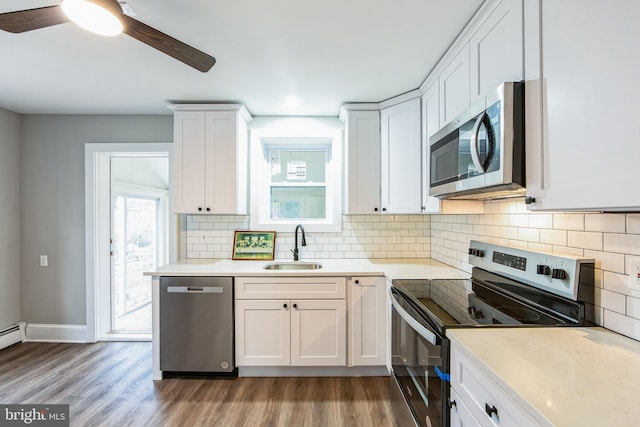 kitchen featuring ceiling fan, sink, stainless steel appliances, white cabinets, and hardwood / wood-style flooring