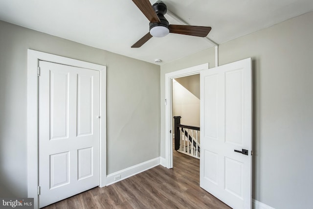 unfurnished bedroom featuring wood-type flooring, a closet, and ceiling fan