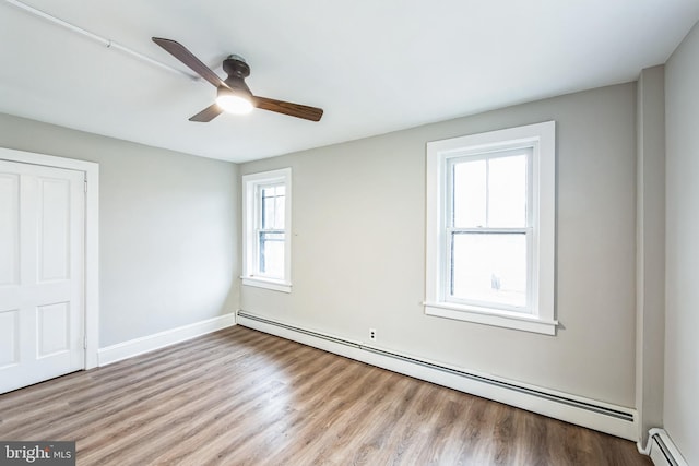 interior space with multiple windows, ceiling fan, and a baseboard radiator