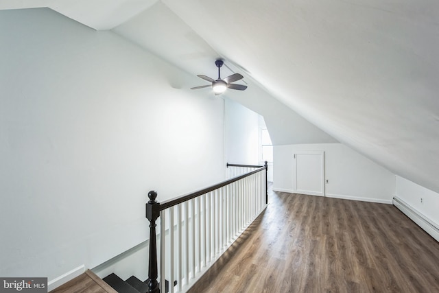 additional living space featuring ceiling fan, dark hardwood / wood-style flooring, lofted ceiling, and a baseboard heating unit