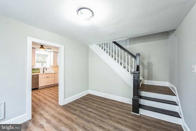 staircase featuring wood-type flooring and sink