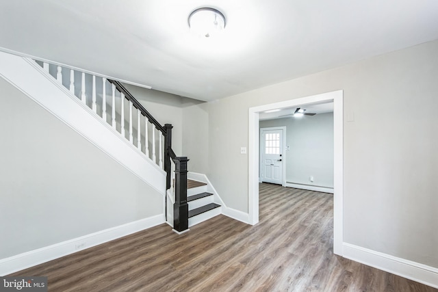 interior space with wood-type flooring and a baseboard heating unit