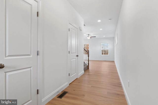 hallway with light hardwood / wood-style floors