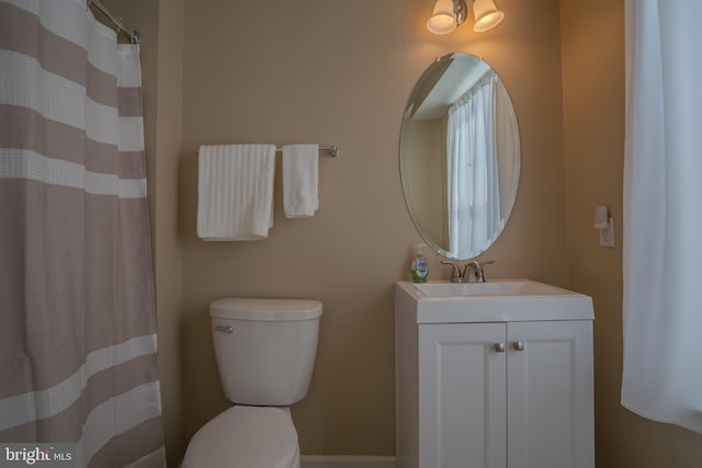 bathroom featuring vanity, curtained shower, and toilet