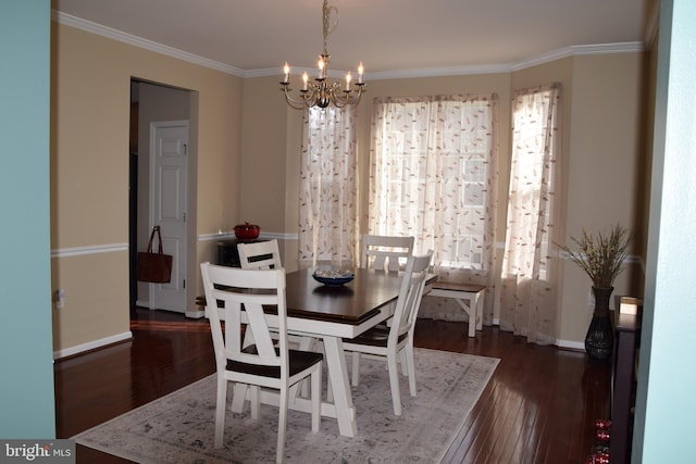 dining area featuring dark hardwood / wood-style flooring, an inviting chandelier, and crown molding