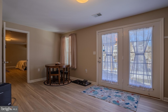 entryway with light hardwood / wood-style floors and french doors