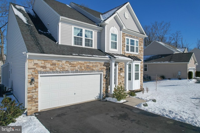 view of front facade with a garage and cooling unit