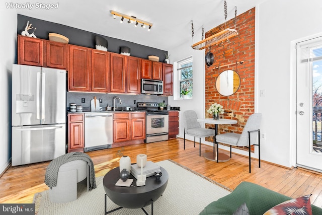 kitchen featuring decorative backsplash, light hardwood / wood-style floors, sink, and appliances with stainless steel finishes