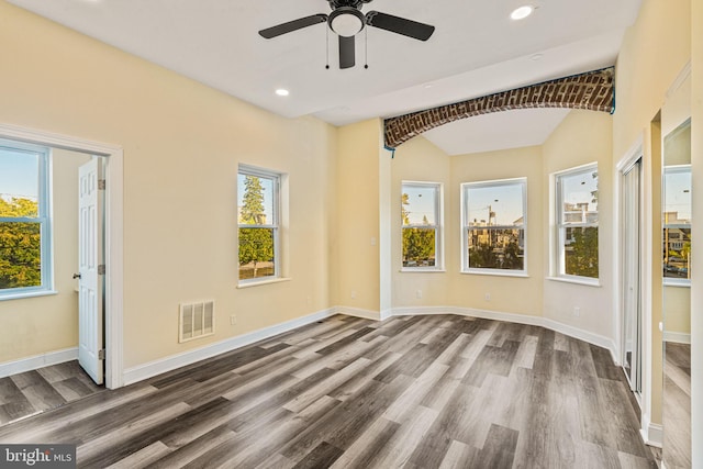 spare room featuring hardwood / wood-style floors, a wealth of natural light, lofted ceiling, and ceiling fan