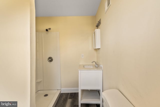 bathroom featuring toilet, vanity, wood-type flooring, and walk in shower