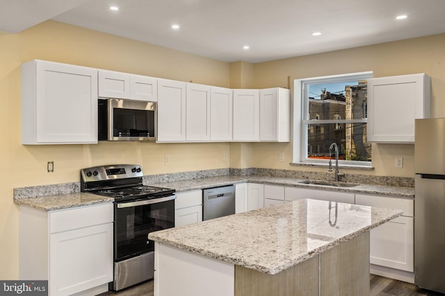 kitchen with white cabinets, a kitchen island, sink, and stainless steel appliances