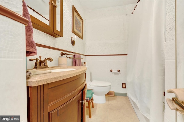 bathroom with tile patterned flooring, vanity, toilet, and tile walls