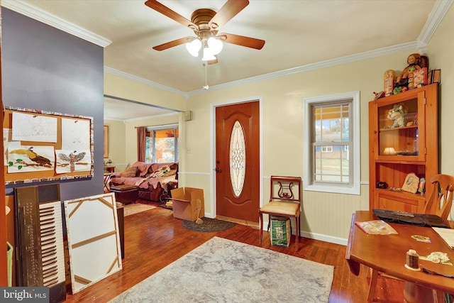 foyer entrance with a wealth of natural light, ceiling fan, dark wood-type flooring, and ornamental molding