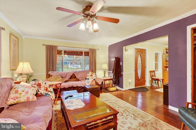 living room with wood-type flooring, ceiling fan, and crown molding