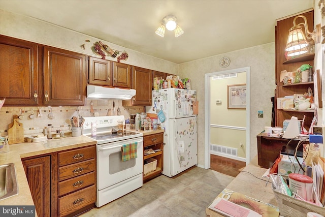 kitchen featuring white appliances, tasteful backsplash, and sink