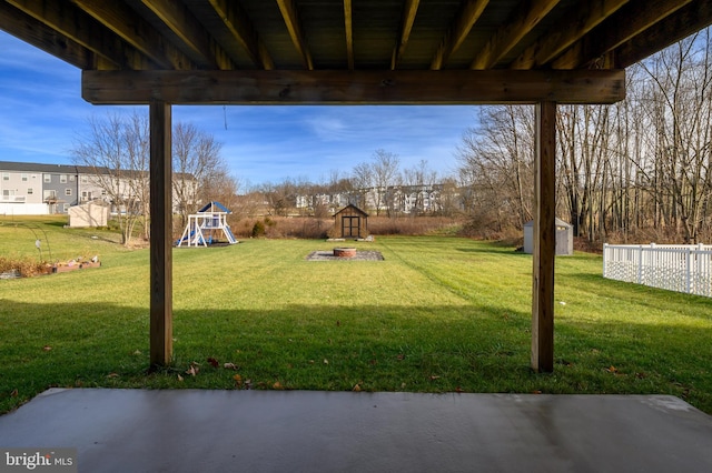 view of yard with a playground, a patio area, and a storage shed