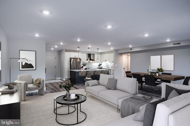 living room with light hardwood / wood-style flooring and sink