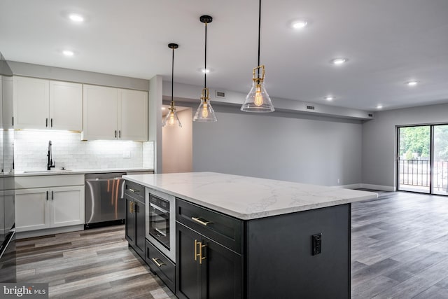 kitchen featuring white cabinets, a kitchen island, light hardwood / wood-style floors, and stainless steel appliances