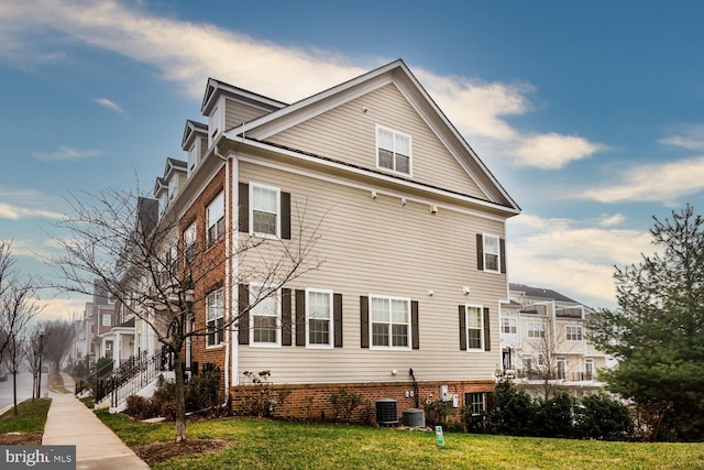 view of home's exterior featuring a lawn and central AC