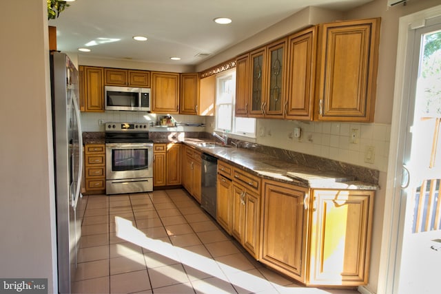 kitchen featuring appliances with stainless steel finishes, sink, a healthy amount of sunlight, and light tile patterned flooring