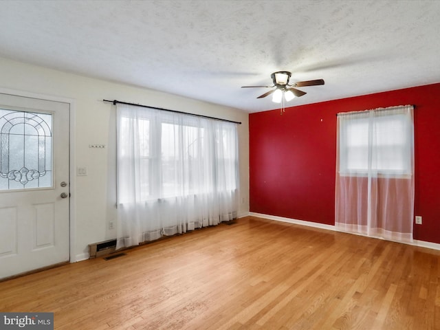 entryway with hardwood / wood-style flooring, ceiling fan, a healthy amount of sunlight, and a textured ceiling