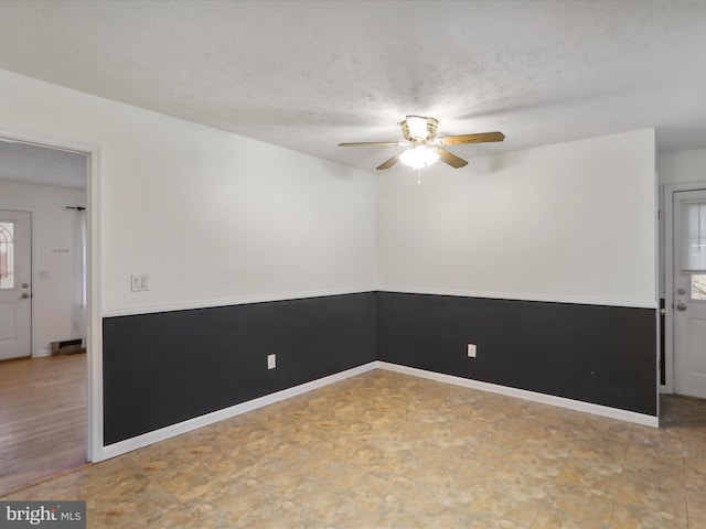 empty room featuring ceiling fan and a textured ceiling