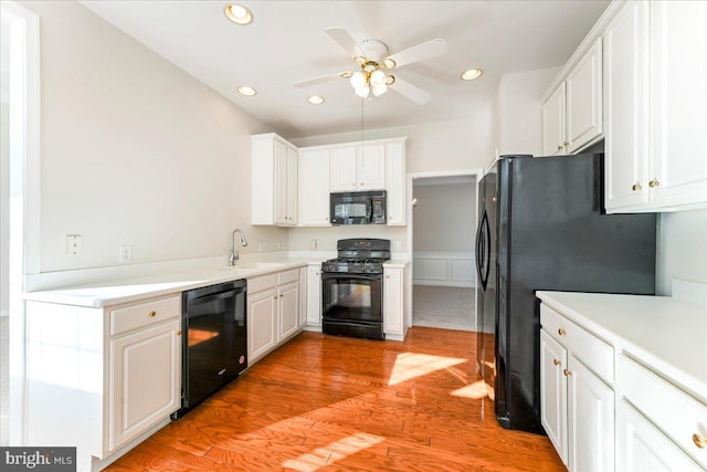 kitchen with white cabinets, light wood-type flooring, ceiling fan, and black appliances