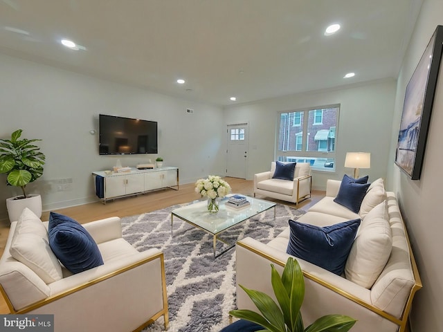 living room with light wood-type flooring and crown molding