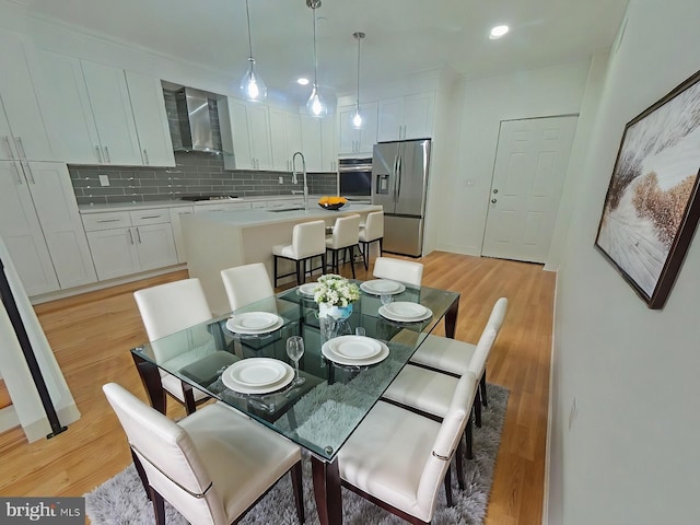 dining area with light wood-type flooring and sink