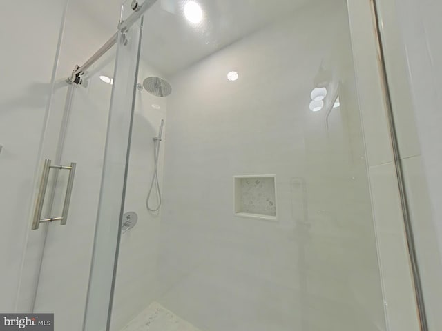 bathroom with a shower with door