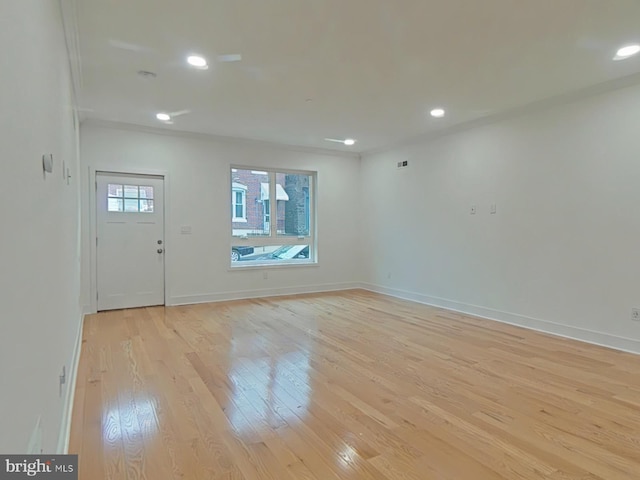 foyer with crown molding and light hardwood / wood-style flooring