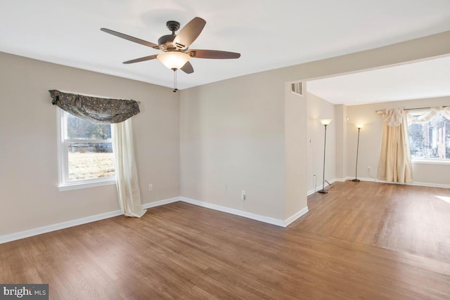 unfurnished room with hardwood / wood-style flooring, ceiling fan, and a healthy amount of sunlight