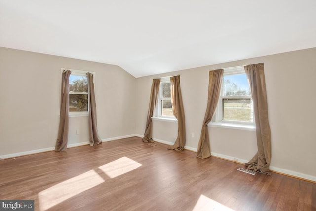 unfurnished room with light hardwood / wood-style flooring and lofted ceiling