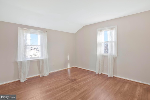 empty room featuring light hardwood / wood-style flooring and lofted ceiling