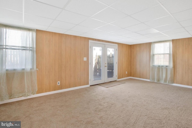 spare room with a paneled ceiling, carpet floors, and french doors