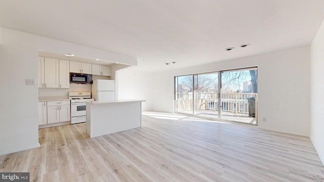 kitchen featuring white cabinets, white appliances, light hardwood / wood-style floors, and a kitchen island