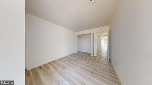 unfurnished bedroom with a closet and light hardwood / wood-style flooring