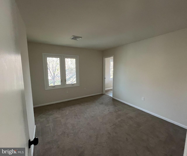 empty room with dark colored carpet