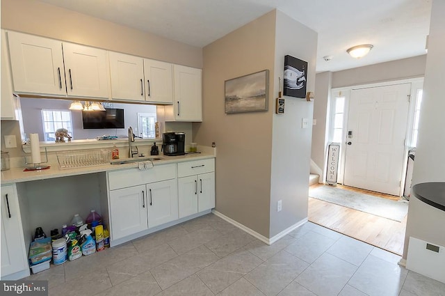 5310 Kelmscot Rd, Rosedale, MD 21237 - kitchen featuring baseboards, light countertops, white cabinets, a sink, and light tile patterned floors