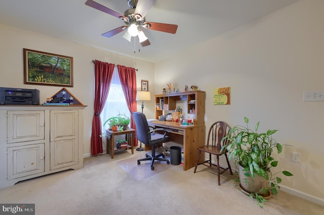 office space with baseboards, a ceiling fan, and light colored carpet