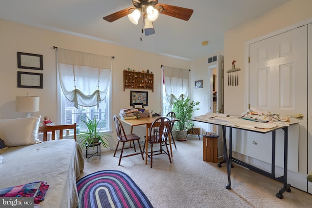 carpeted dining space with visible vents and ceiling fan