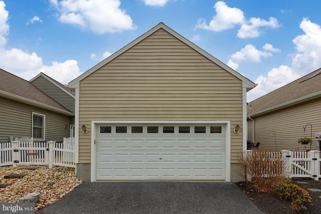 garage with driveway and fence