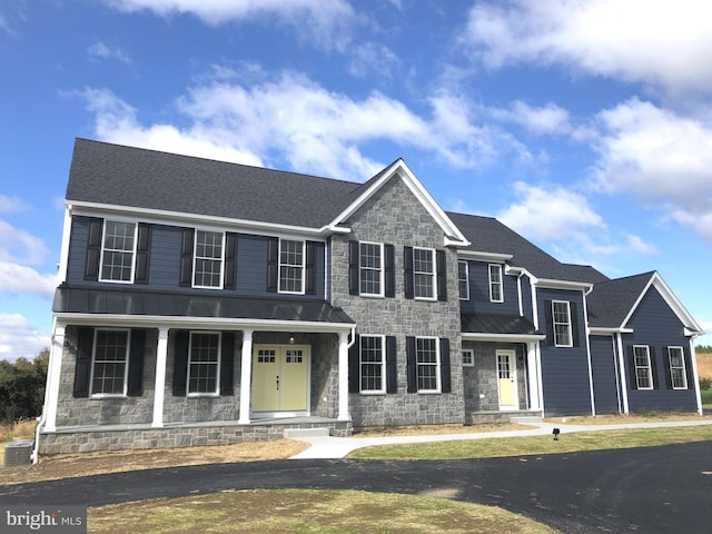 view of front facade with covered porch and central AC unit