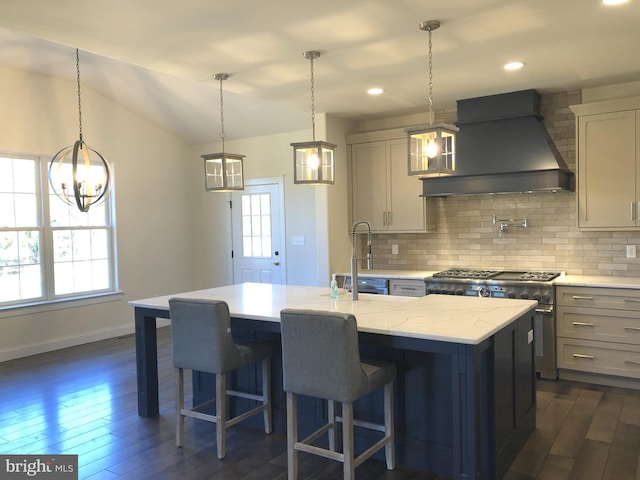 kitchen with high end range, dark hardwood / wood-style floors, a center island with sink, and custom exhaust hood