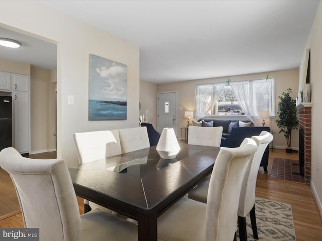 dining room with a fireplace and light wood-type flooring